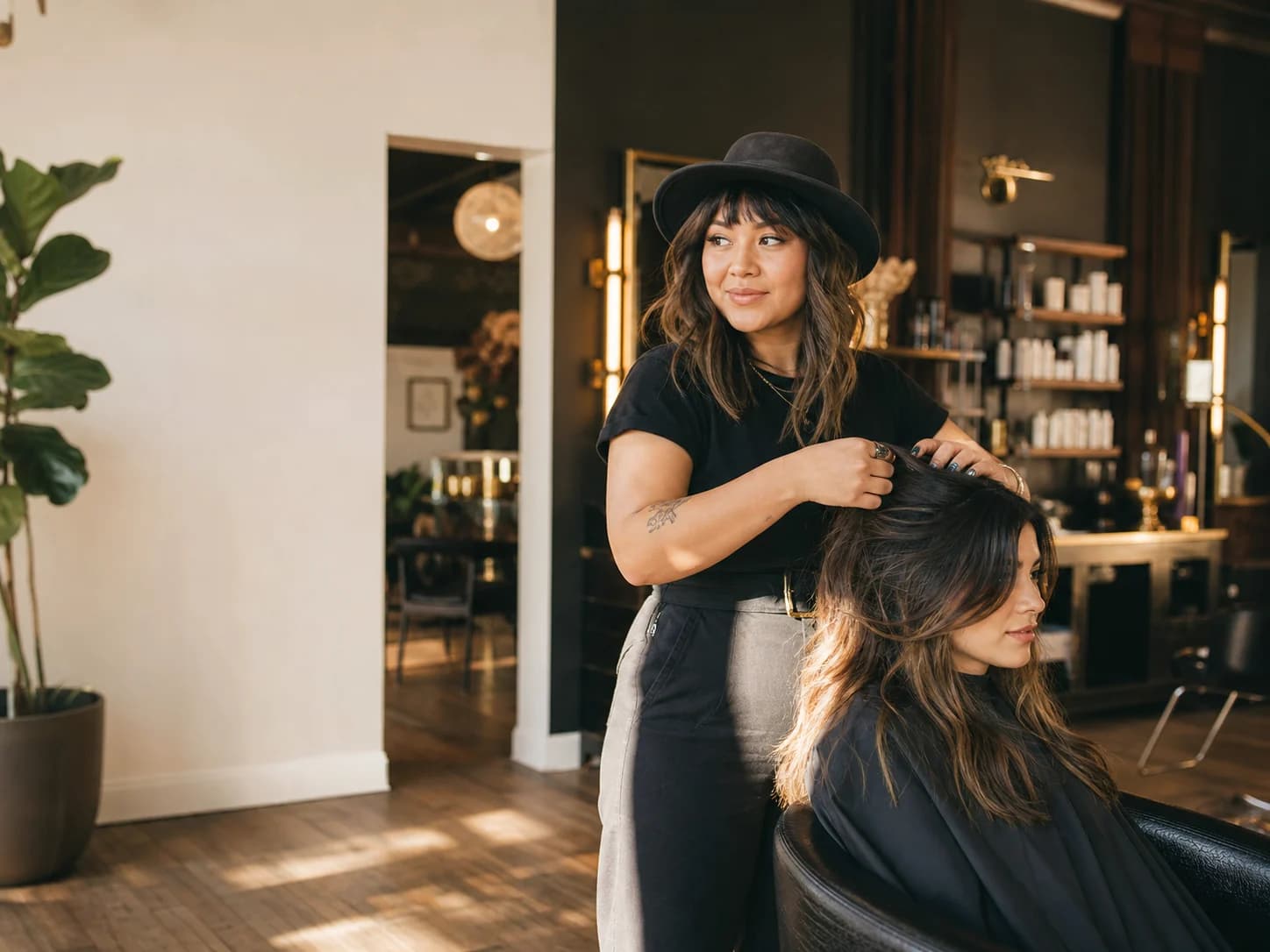 A salon owner styling a client's hair in her studio